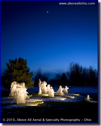 A crescent moon shines above a Christmas display of life sized angels at dusk at a home near Willard, Ohio
